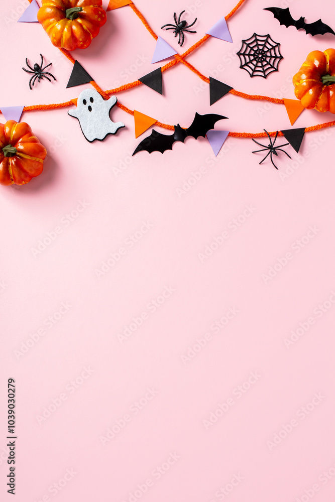 Obraz premium Halloween flat lay with bunting flag garland, orange pumpkins, black spiders, bats, ghosts, and spider webs on a pink background