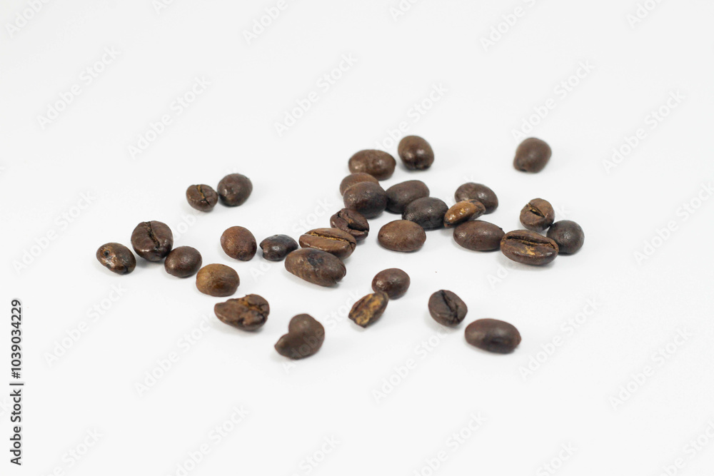 Naklejka premium A small amount of fresh roasted robusta and arabica coffee beans, isolated on white background