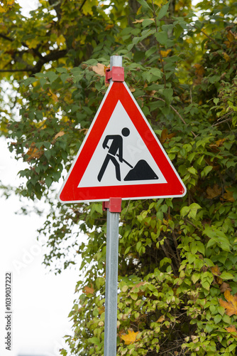 Temporary repairs: improvement of urban infrastructure. A road sign warning drivers about upcoming repair work. Temporary signs and pointers.