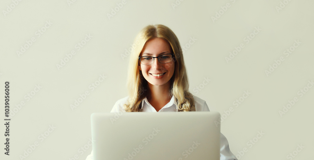 Naklejka premium Happy woman working with laptop sitting at desk in office or home