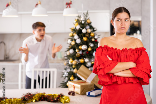 Young couple quarreling - husband expresses displeasure to wife during new year celebration photo