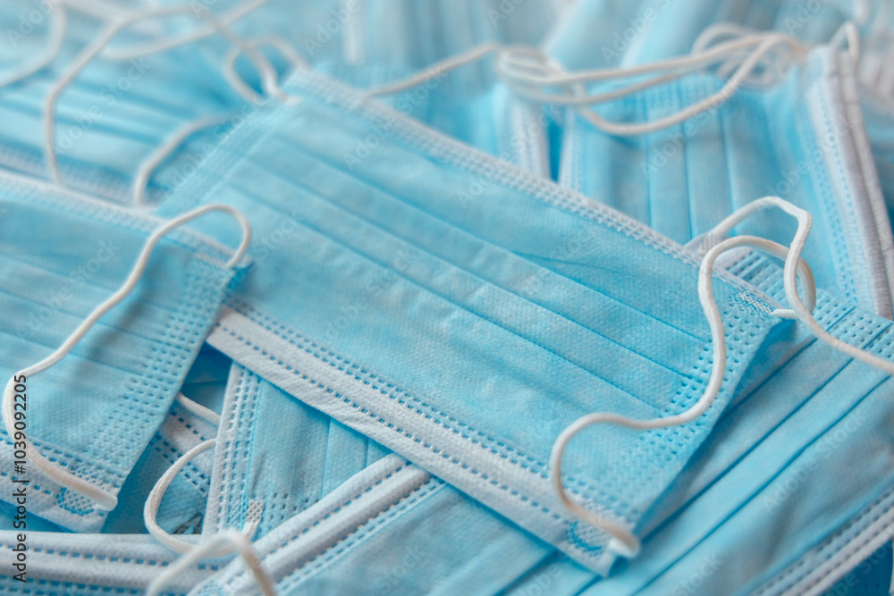 Many sterile medical blue disposable masks. Stack of new medical masks organized.