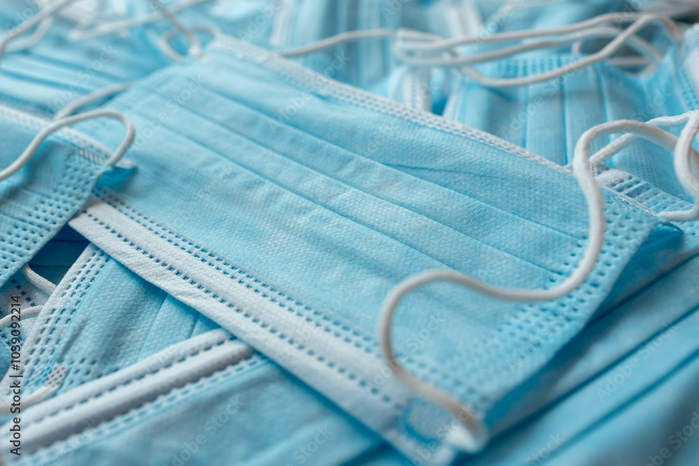 Many sterile medical blue disposable masks. Stack of new medical masks organized.