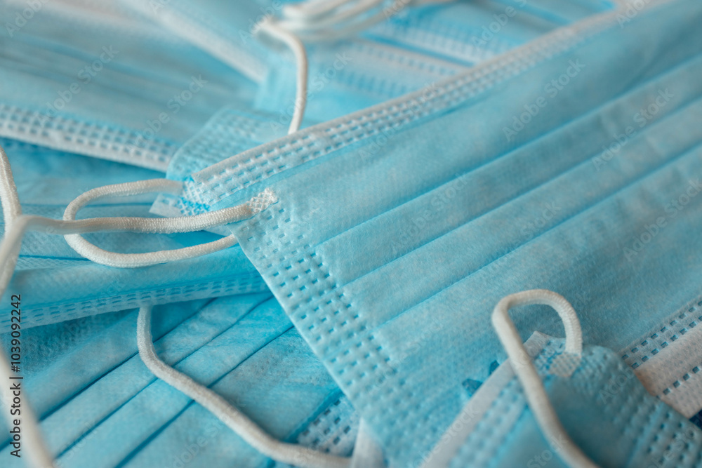 Many sterile medical blue disposable masks. Stack of new medical masks organized.