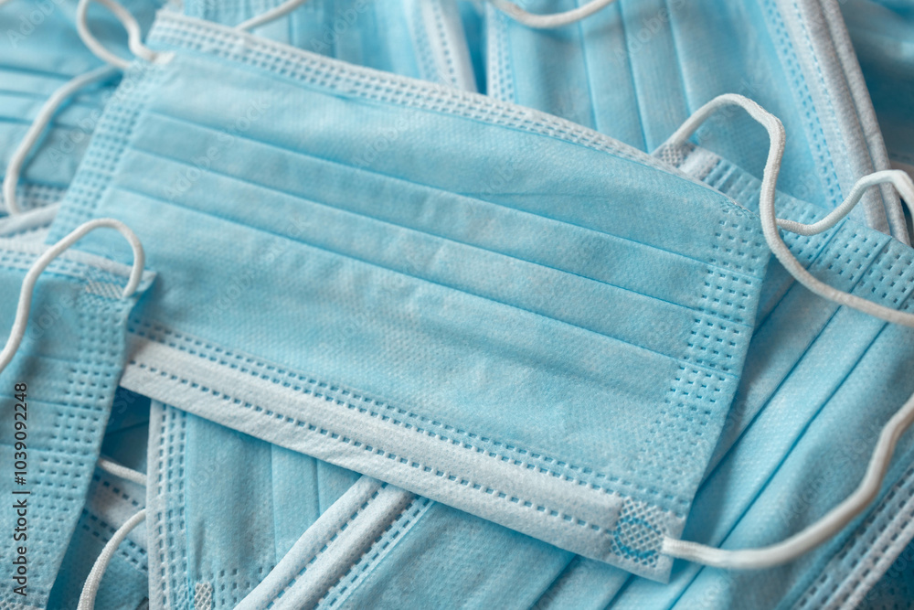 Many sterile medical blue disposable masks. Stack of new medical masks organized.