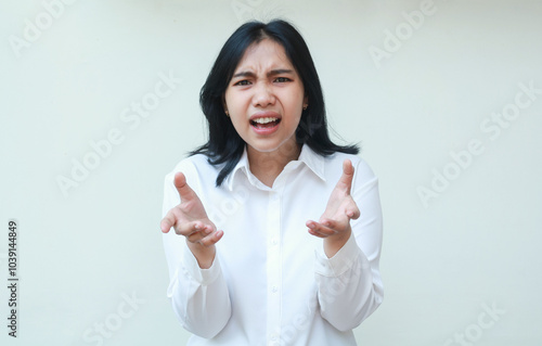 so what. furious asian business woman keep palms sideways and shrugging shoulders questioning what happen with angry frowning face wear formal white shirt standing over isolated background