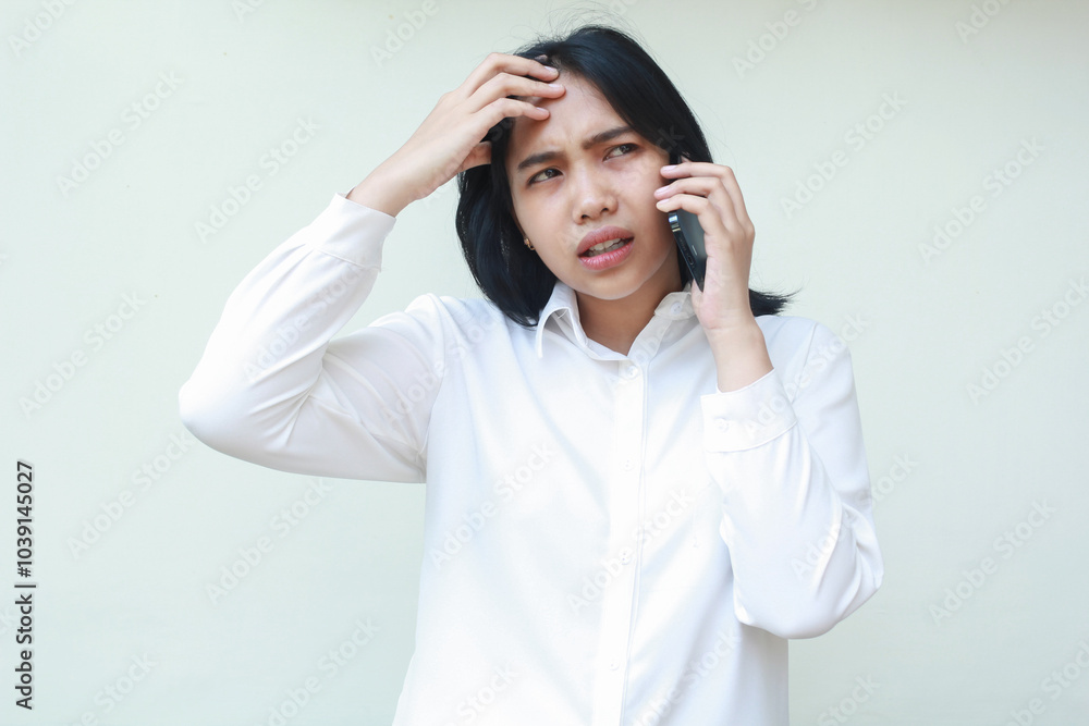 portrait of confused asian woman manager speaking on smartphone touching her forehead looking away, show regret and puzzled face expression for mistakes, wear white formal suit, standing portrait of confused asian woman manager speaking on smartphone touching her forehead looking away, show regret and puzzled face expression for mistakes, wear white formal suit, standing