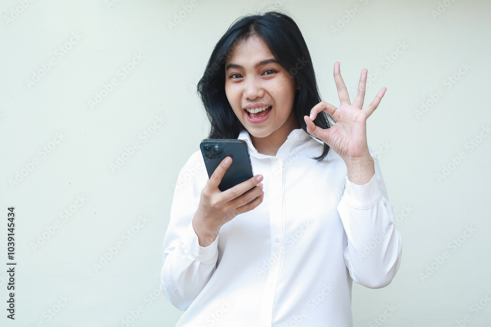 delighted playful asian young woman secretary wearing white formal suit shirt showing ok sign, okay symbol, looking camera satisfied of online shopping application, recommend gesture delighted playful asian young woman secretary wearing white formal suit shirt showing ok sign, okay symbol, looking camera satisfied of online shopping application, recommend gesture