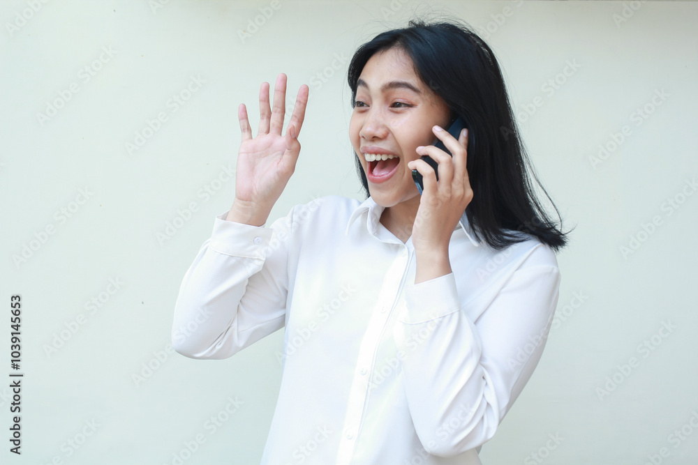 playful friendly asian business woman raising palms say hi and look away while talking on mobile phone wearing white suit formal shirt, said hello welcoming gesture, standing over isolated background playful friendly asian business woman raising palms say hi and look away while talking on mobile phone wearing white suit formal shirt, said hello welcoming gesture, standing over isolated background