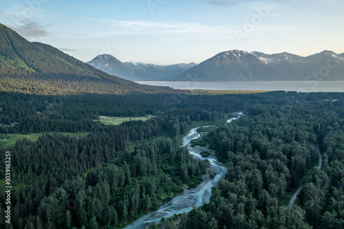 Aerial view of river landscape and Alyeska Highway in Girdwood, Alaska with Turnagain Arm and surrounding mountains near Anchorage