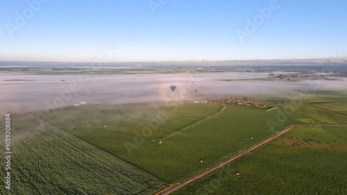 Aerial Sunrise View of Misty Farmlands and Fields with Hot Air Balloon Over Canterbury Plains and Southern Alps, New Zealand photo