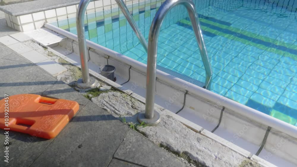 Water splashes over the side of an outdoor pool. Water splashes over the side of an outdoor pool.