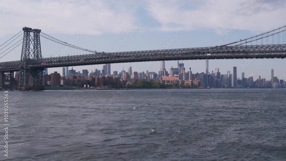 New York City skyline from ferry boat. Manhattan midtown highrise skyscrapers view from ferryboat. East river waterfront panorama, riverfront buildings architecture near water USA. Williamsburg Bridge New York City skyline from ferry boat. Manhattan midtown highrise skyscrapers view from ferryboat. East river waterfront panorama, riverfront buildings architecture near water USA. Williamsburg Bridge