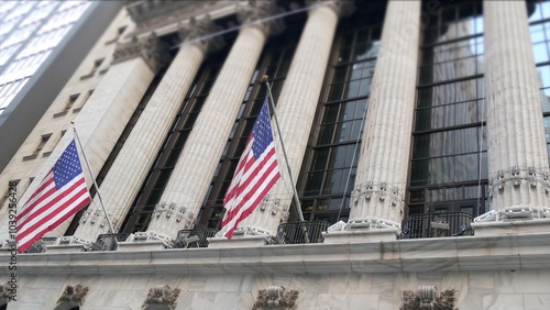 New York City, United States. Lower Manhattan Downtown Financial District urban architecture exterior. American flag. Wall street Stock Exchange building facade columns, USA Stock Market trading, NYC.