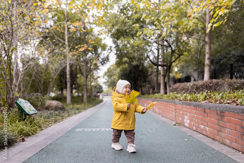 Cute caucasian baby girl one year old smiling during autumnal walk outdoor. Happy healthy kid with smiley face enjoying life and fall season