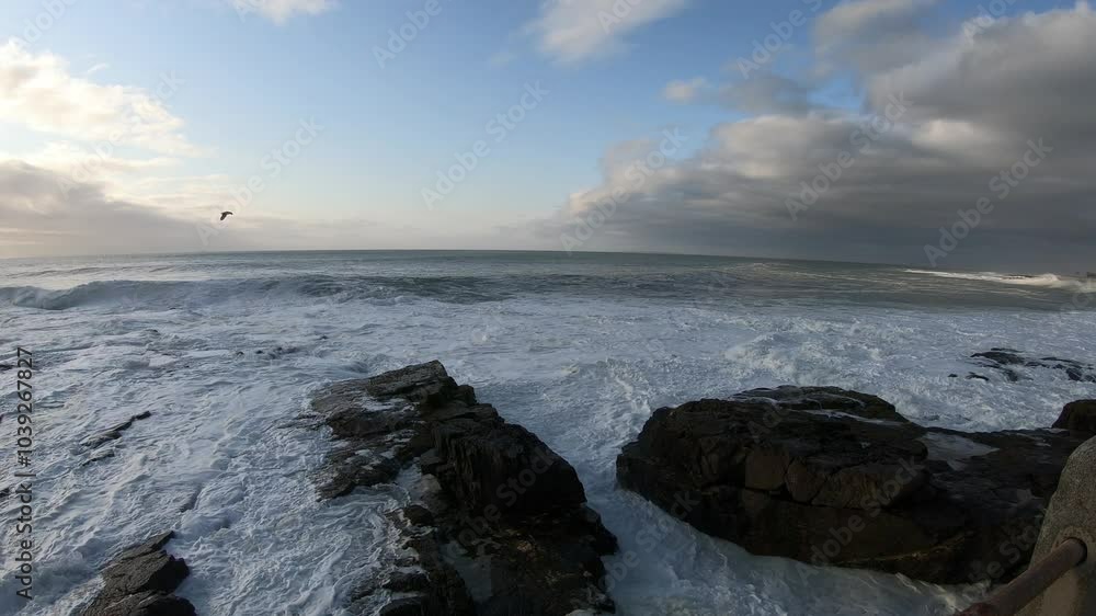 Waves smashing against the big boulders along a rocky coastline at sunset Waves smashing against the big boulders along a rocky coastline at sunset