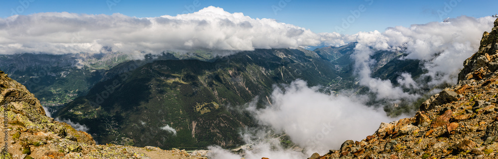 Panorama top view behind rock through clouds on valley under Mont Blanc from france normal way to top Panorama top view behind rock through clouds on valley under Mont Blanc from france normal way to top