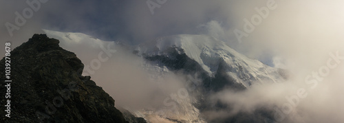 Tops Dôme du Goûter, Pointe Bayeux in snow cover through clouds with blue sky in france normal way to Mont Blanc