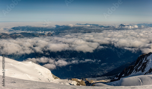 Steep huge rocky way to old unused Goûter refuge engulfed in snow with valley background