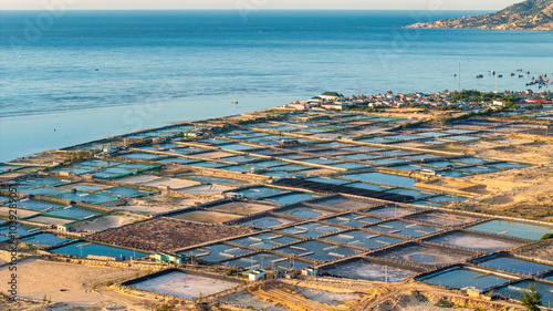 Aerial view of the prawn farm with aerator pump in front of Ninh Phuoc, Ninh Thuan, Vietnam. The growing aquaculture business continuously threatening the nearby wetlands. photo