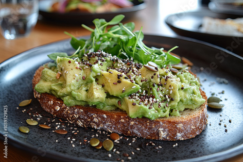 A plate of avocado toast with whole grain bread and a sprinkle of seeds photo