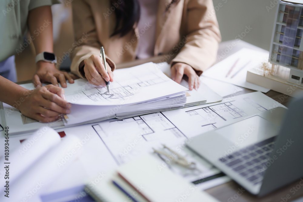 Two female architects discussing about interior designing building project and drawing on blueprint Two female architects discussing about interior designing building project and drawing on blueprint