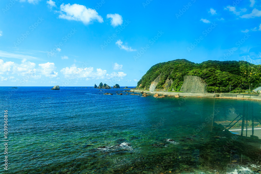 Fototapeta premium 古の大行者、役小角に由来があると言われる、蓑掛岩、蓑掛島。 奇岩が連なる。 伊豆半島の最南端、下田駅から出発する東海バス。 海岸線を走り、中木へと至る。 静岡県伊豆半島南伊豆町中木ヒリゾ浜-2024年 