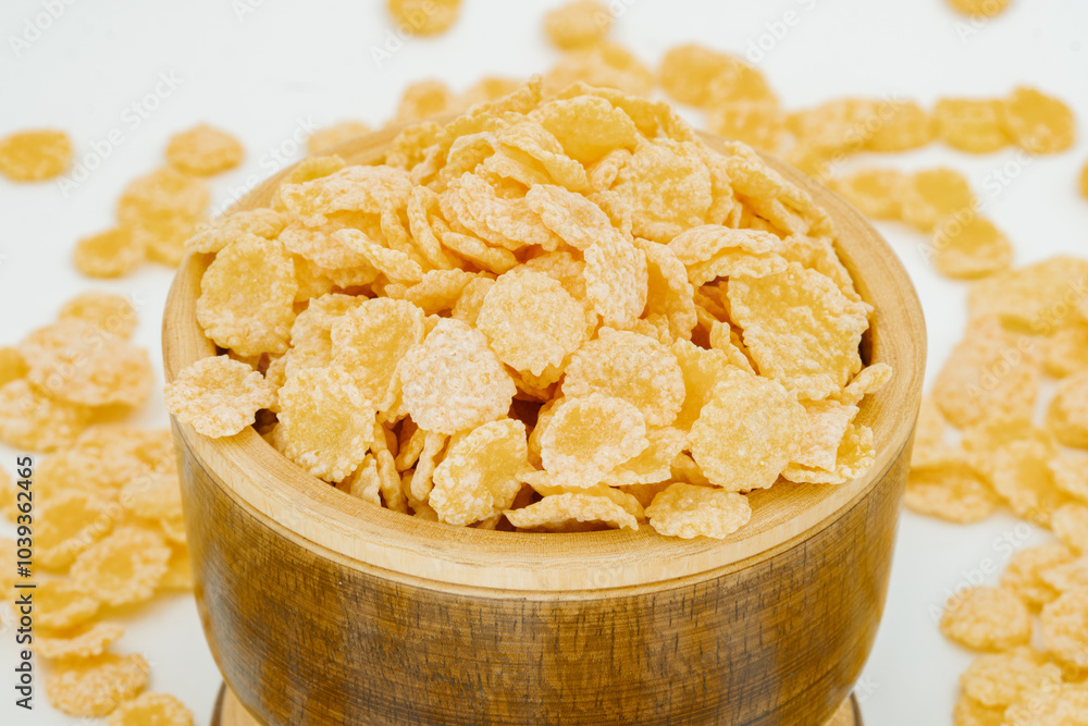Close-up of cornflakes in a wooden bowl with scattered cereal on a white background, perfect for breakfast and food-related projects. Cornflakes in Wooden Bowl with Scattered Cereal Close-up of cornflakes in a wooden bowl with scattered cereal on a white background, perfect for breakfast and food-related projects. Cornflakes in Wooden Bowl with Scattered Cereal