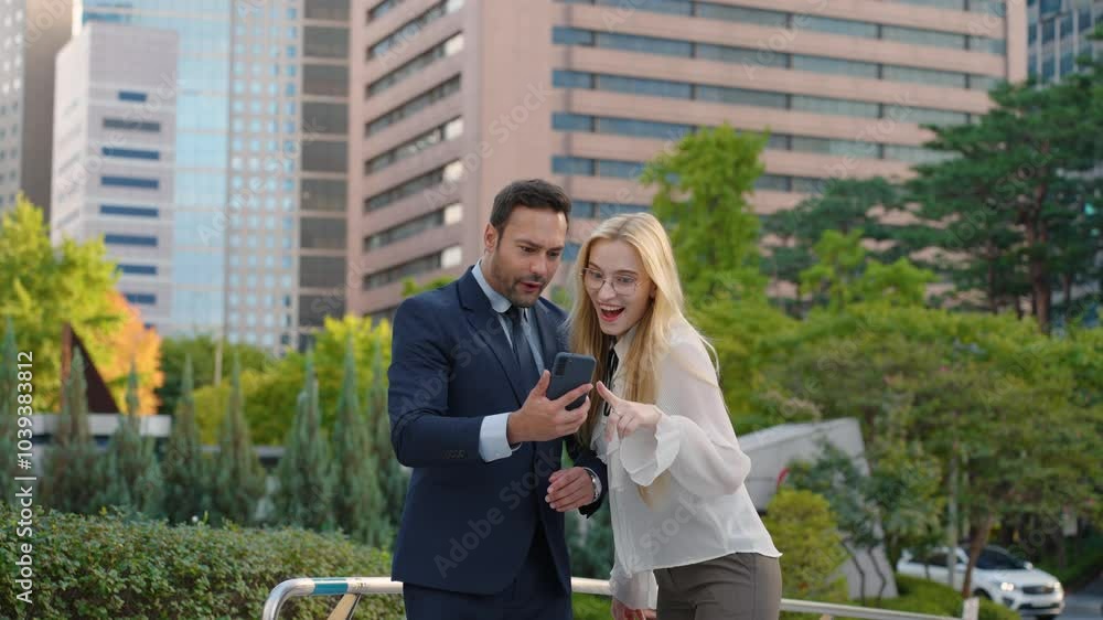Two Excited Business People Man and Woman Get Good News Achievement on Mobile Phone. Businessman and Businesswoman Winning Bet Trade, Raises Hands Up Overexcited, Smiling, Jumping from Success Two Excited Business People Man and Woman Get Good News Achievement on Mobile Phone. Businessman and Businesswoman Winning Bet Trade, Raises Hands Up Overexcited, Smiling, Jumping from Success