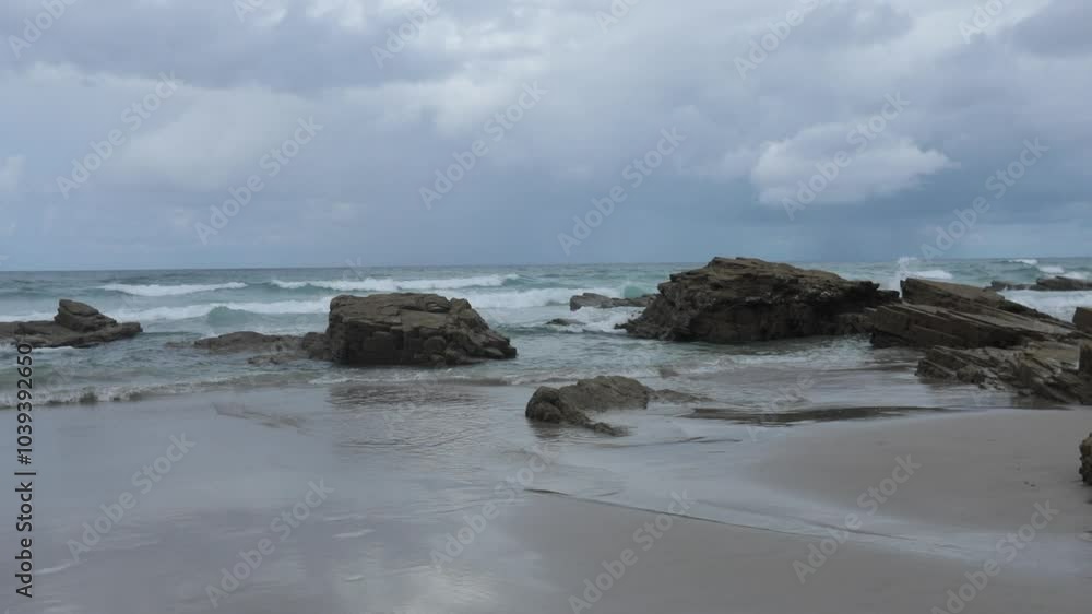 Rocky beach in Vigo, Galicia on a cloudy day with calm waves and serene coastal atmosphere Rocky beach in Vigo, Galicia on a cloudy day with calm waves and serene coastal atmosphere