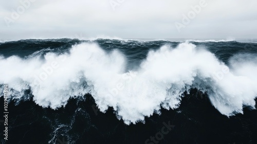 Powerful ocean wave crashing against rugged rocky cliffs showcasing the raw unbridled energy and strength of nature  This dramatic seascape captures the sheer force and motion of the waves photo