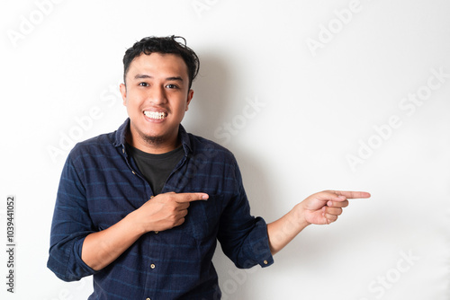 Adult Asian man smiling confident with both hand pointing to the left side photo