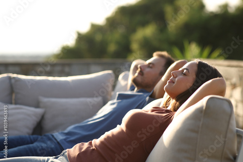 Relaxed couple sitting in an exterior sofa in a terrace