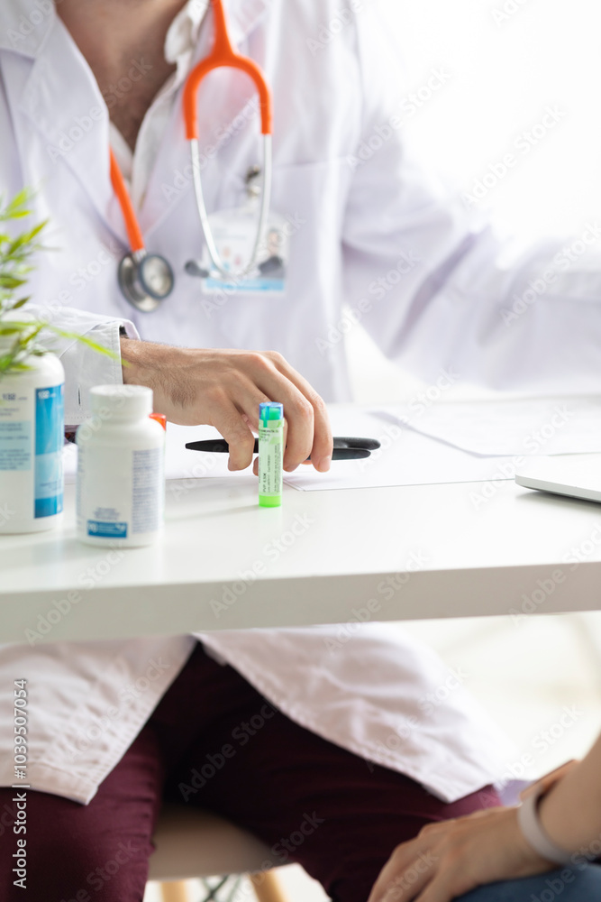 Doctor prescribing homeopathic medicine to patient at desk Doctor prescribing homeopathic medicine to patient at desk