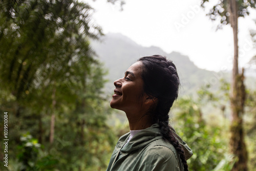 Happy woman with braided hair in front of trees photo