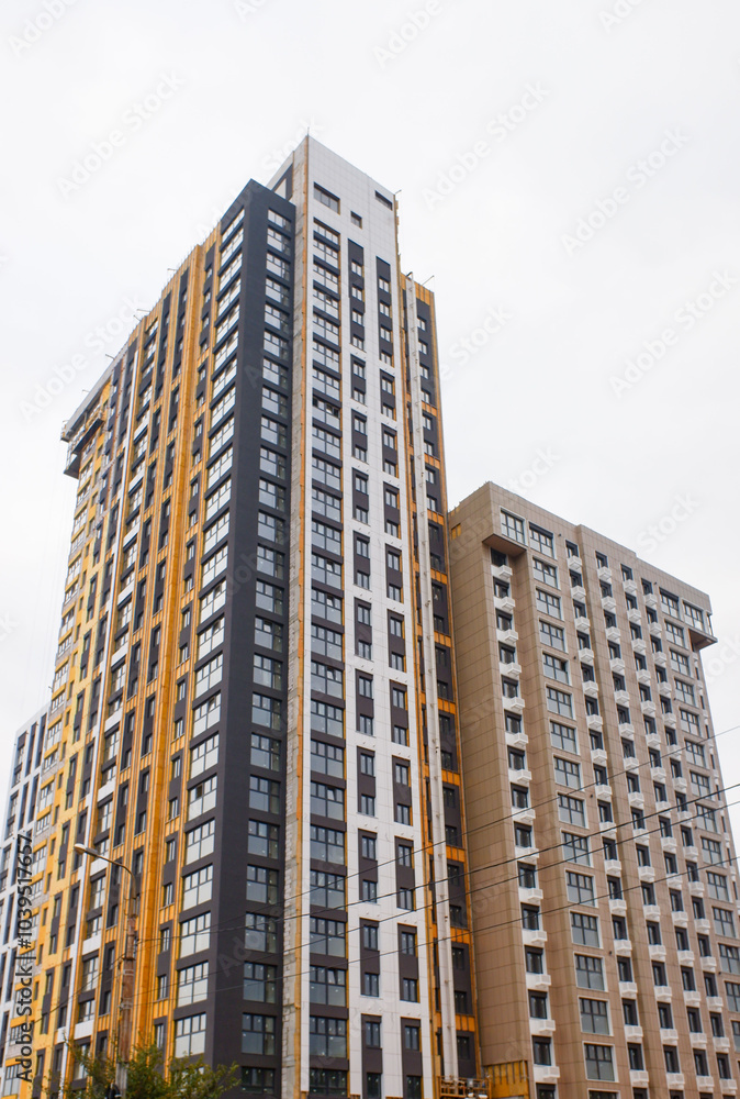 A tall building with a gold facade and a white roof A tall building with a gold facade and a white roof