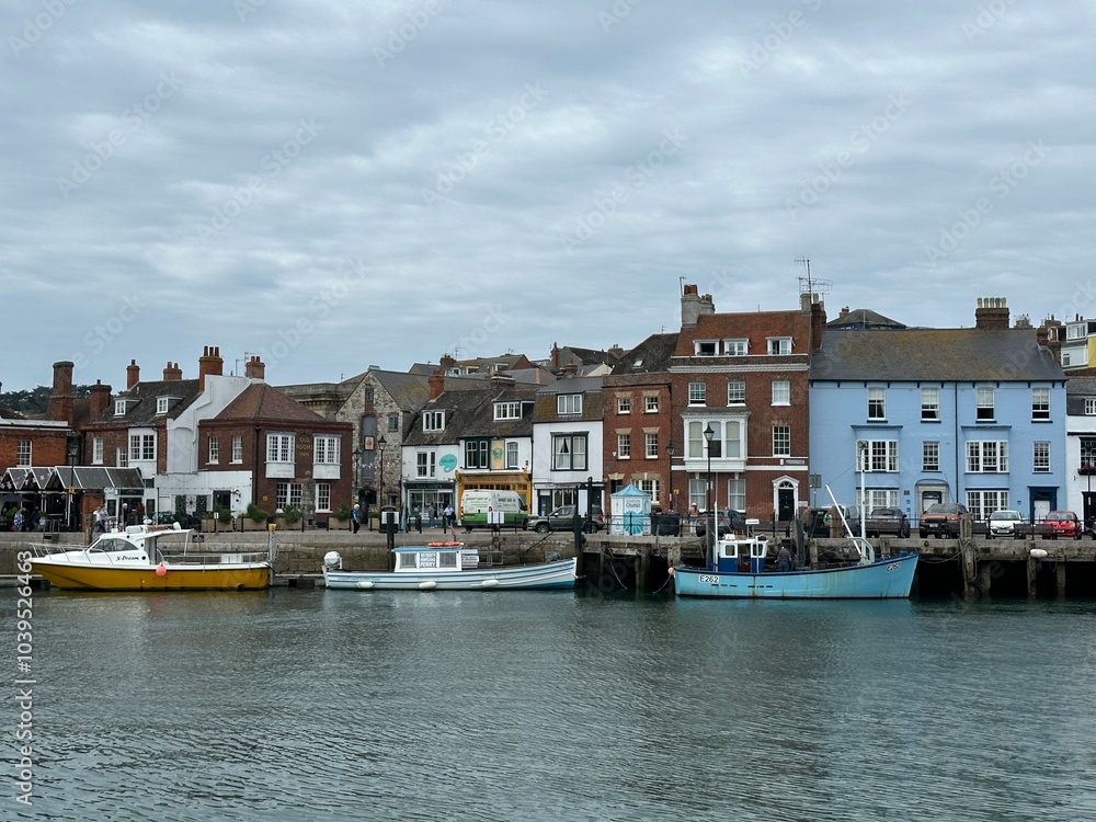 Old buildings and boats in the harbour of Weymouth, England, United Kingdom, July 2023 Old buildings and boats in the harbour of Weymouth, England, United Kingdom, July 2023