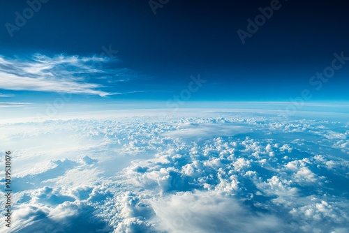 A beautifully captured view of Earth from space, displaying the vastness of the planet and its enveloping atmosphere, surrounded by a sea of white, fluffy clouds. photo