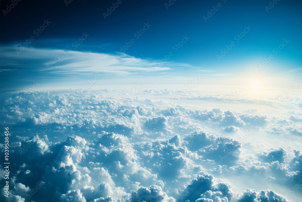 Naklejka premium A stunning aerial view of dense, white clouds illuminated by the setting sun, casting warm hues and creating a serene, ethereal atmosphere above the earth.