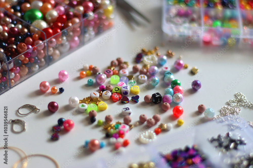 Colorful beads, letter beads, threads and other jewelry making supplies on white background. Making friendship bracelets concept. Selective focus.