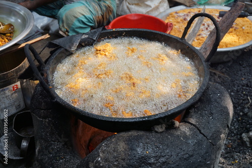 Mix vegetable pakora making and being displayed by a street food vendor, Crispy onion and potato pakoda selling on a market, Spicy veg pakora or pakoda displayed on a rural fair for sale