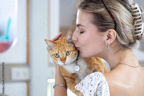 Foto Cat owner is kissing and hugging her ginger cat with love and care after rescuin