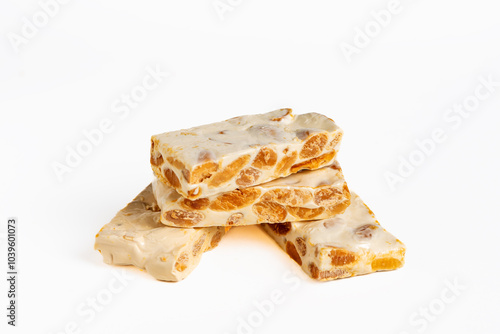 Several portions of hard almond nougat in close-up and on a white background, a typical Christmas sweet.