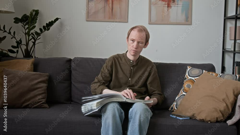 Visually challenged man reading book written in tactile system while spending free time at home Visually challenged man reading book written in tactile system while spending free time at home