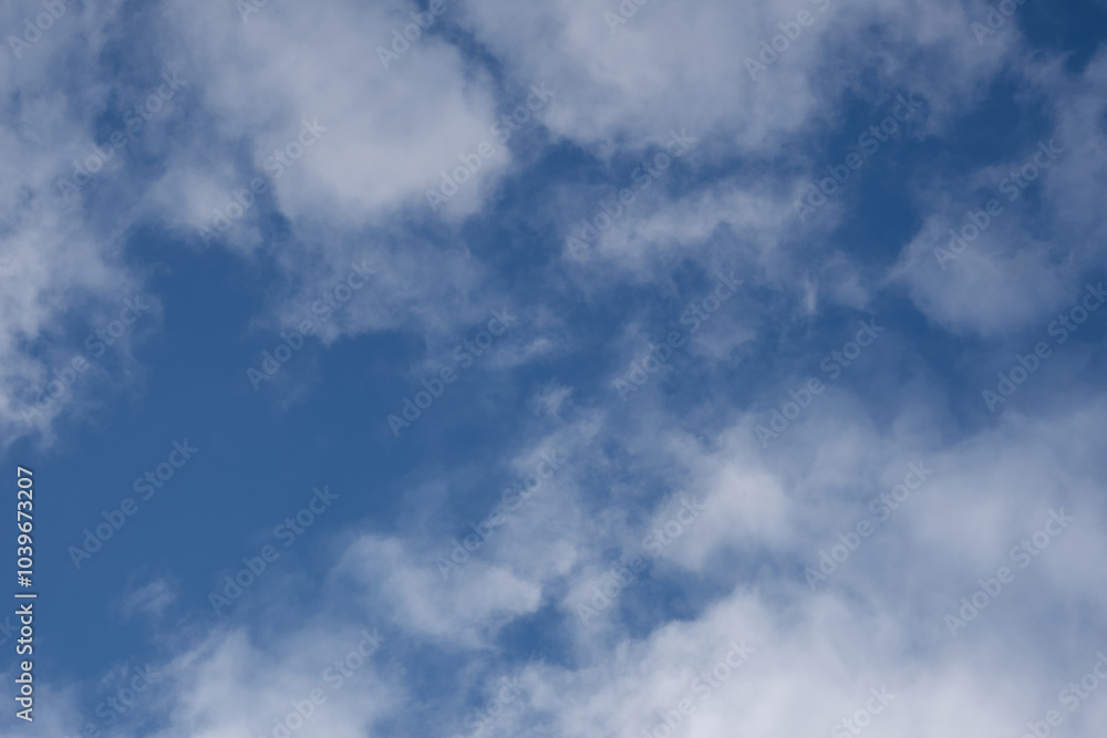 Blue sky with white clouds on a bright sunny day. Purity and harmony of nature, feeling of peace