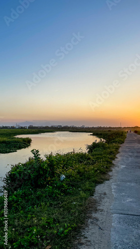 Wallpaper Mural Sunset over a serene rural landscape by a river, representing tranquility and escape from urban life Torontodigital.ca