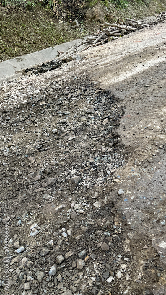 A rural dirt road suffers erosion and damage caused by natural weathering, highlighting infrastructure challenges in remote areas A rural dirt road suffers erosion and damage caused by natural weathering, highlighting infrastructure challenges in remote areas