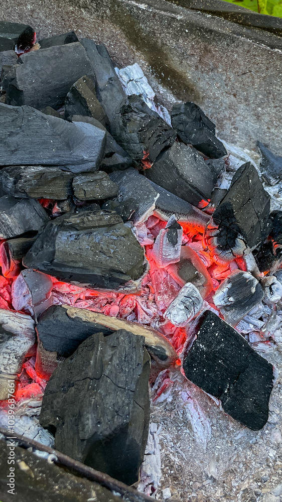 Glowing hot charcoal briquettes in a barbecue grill, symbolizing summer barbecues and outdoor cooking during Memorial Day celebrations Glowing hot charcoal briquettes in a barbecue grill, symbolizing summer barbecues and outdoor cooking during Memorial Day celebrations