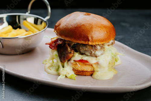 Juicy gourmet burger with melted cheese, bacon, and fries.Perfect for a delicious treat photo