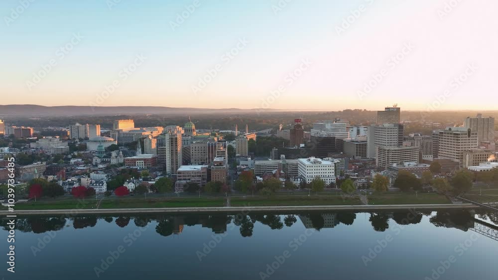 Aerial view of downtown Harrisburg, Pennsylvania, at sunrise, featuring a mix of modern and historic buildings, tree-lined streets, and the Susquehanna River reflecting the soft morning light. Aerial view of downtown Harrisburg, Pennsylvania, at sunrise, featuring a mix of modern and historic buildings, tree-lined streets, and the Susquehanna River reflecting the soft morning light.